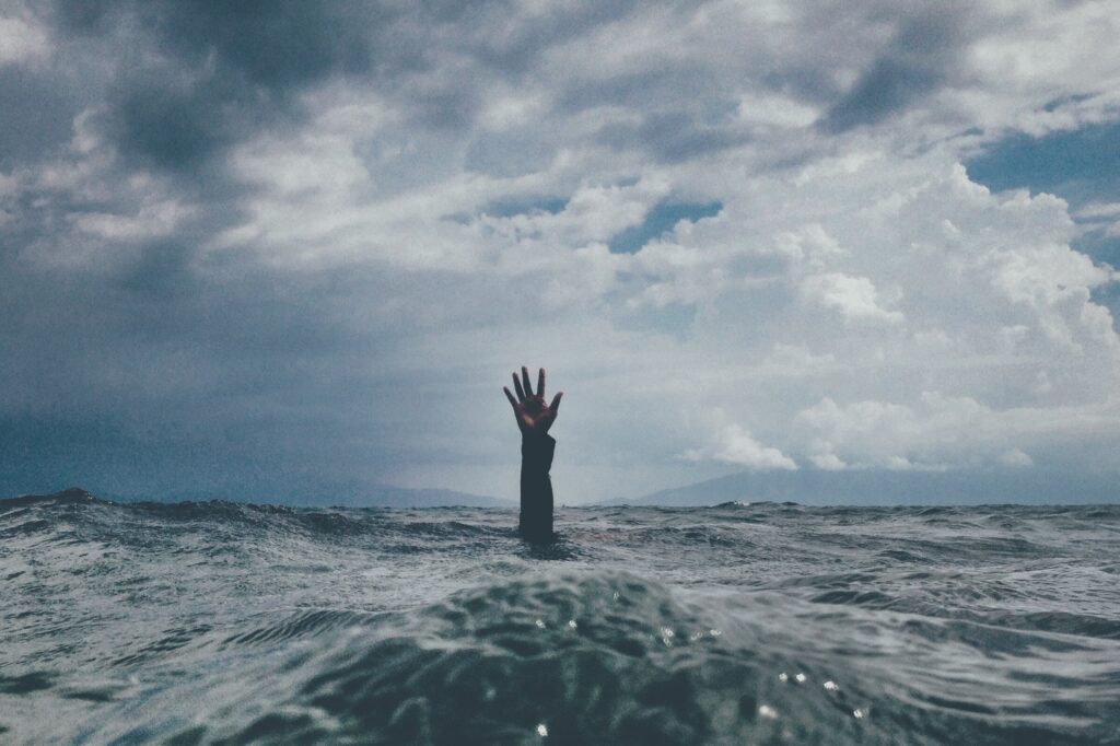 a hand rising from the sea illustrating help on writing